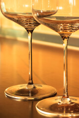 Empty wine glasses on thin legs in the interior, the container for the alcoholic beverage. Yellow background. High quality photo