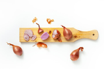 Whole and cut shallot over white background cutting board. Top view layout