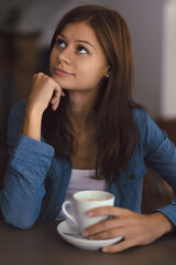 Young girl in cafe with cup of hot chocolade thinking about life