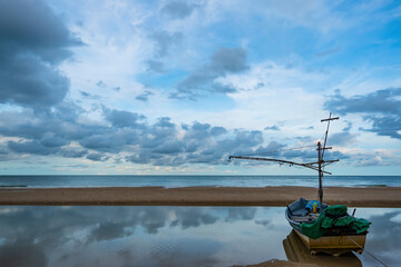 Fishing boats moored on Hua Hin Beach, Thailand on a cloudy day.