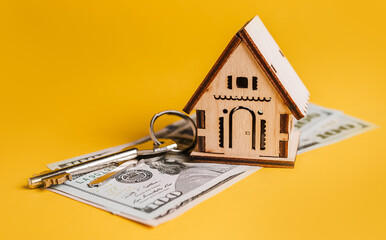 House miniature model, keys and money on a yellow background. Investment, real estate, home, housing