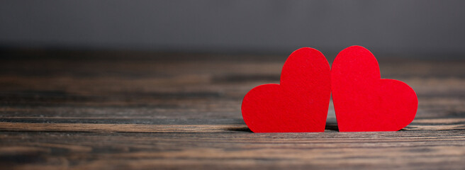 pair of red hearts on wooden background, love and valentine concept on a wooden table