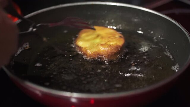 Woman removing Rabanadas (Portuguese French Toast) from hot skillet to drain on paper towels - Close up