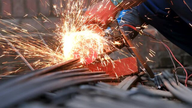 Cutting Iron Bars. Close-up shot of hands of an Asian worker cutting TMT bar.