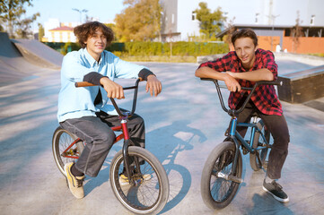Fototapeta premium Bmx riders on bikes, training on ramp in skatepark