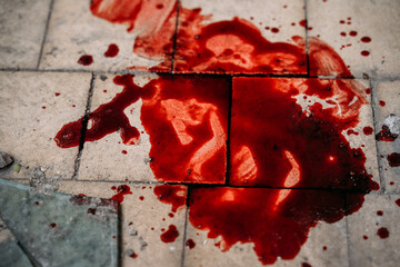 Puddle of blood on dirty tiled floor, concept of victim of violence or murder crime.