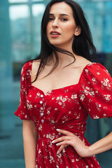 Young elegant girl posing at city street. Pretty beautiful business woman in elegant dress against city background.