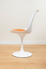 white chair with orange cushion