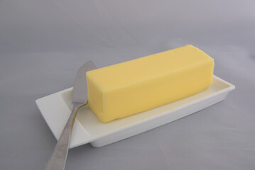 Butter and butter knife on a white dish.