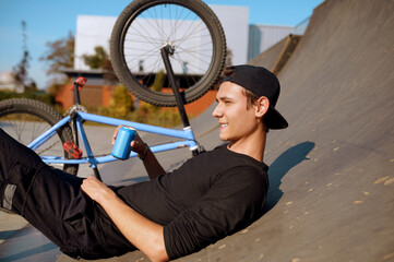 Young male bmx biker leisures on ramp in skatepark