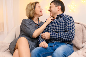 portrait of adult couple sitting on a sofa at home