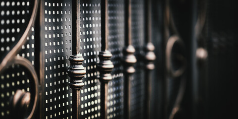 Fragment of wrought iron gates close up, angle view. Handmade forged products, background with copy...