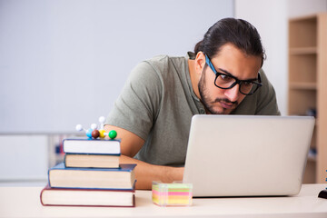 Young male student physicist in tele-education concept