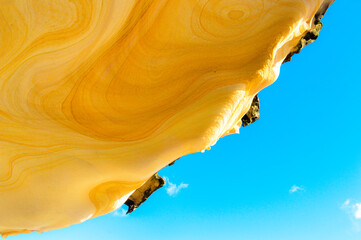 abstract yellow and orange sandstone pattern with blue sky