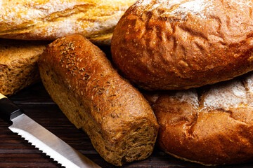 Fresh bread and a knife for slicing bread on a counter in a bakery close-up.