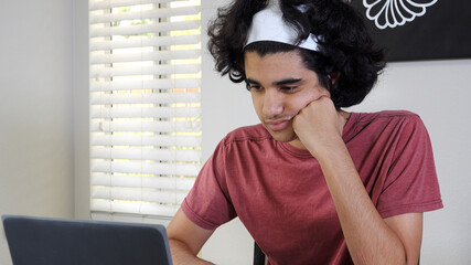 Teen looks bored and disengaged during remote learning