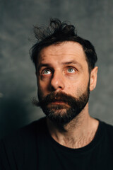 Portrait of a courageous guy with a beard and mustache on a canvas background