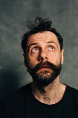 Obraz premium Portrait of a courageous guy with a beard and mustache on a canvas background