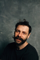 Fototapeta premium Portrait of a courageous guy with a beard and mustache on a canvas background