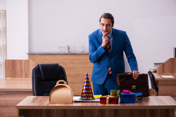 Young male employee celebrating Christmas at workplace