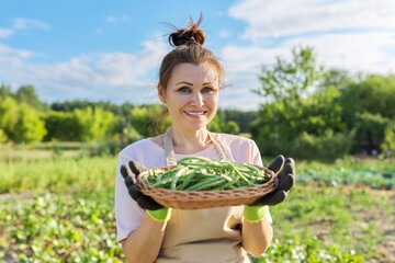 Woman gardener farmer with basket of fresh green string beans