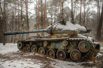 Ein alter Panzer im Gelände mit etwas Schnee bedeckt
