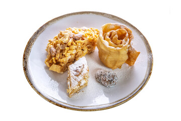 Dessert of fresh pastries, chak-chak, sprinkled with powdered sugar in a plate on a white isolated background. Traditional Tatar national dish.