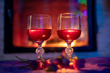 two glasses with red wine, near the fireplace, evening, blurred background