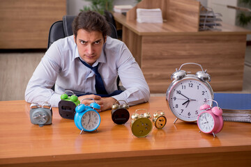 Young male employee sleeping in the office in time management co