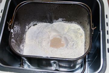 Ingredients for preparing bread in bread pan of electric bread maker