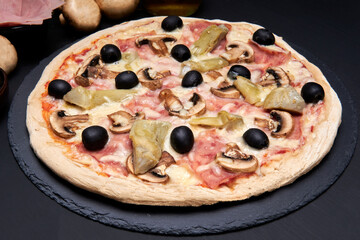 4 seasons pizza (quattro stagioni) made with black olives, mushrooms, ham and artichokes.