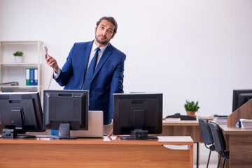 Young male employee in multitasking concept