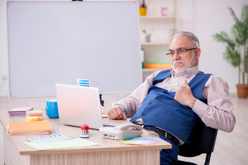 Obraz premium Old male designer working in the office