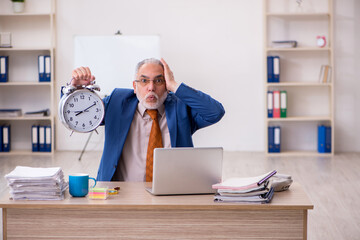 Old businessman employee in time management concept