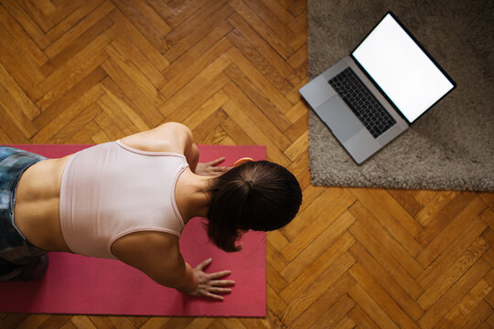 Virtual Online Exercise. Woman Training From Computer At Home Fitness Training, Stretching Exercises Online At Living Room With Laptop. Lying On Fitness Mat Online Yoga Lessons Blank Laptop Screen