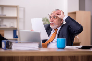 Old male employee working in the office