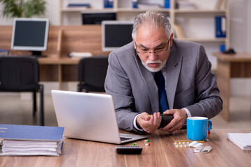 Coronavirus infected old businessman employee sitting in the off