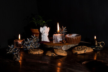 Festive wood table with cookies, candles and angel