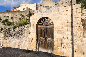 A vintage, weathered brown door in the ancient sassi city of Matera, Italy