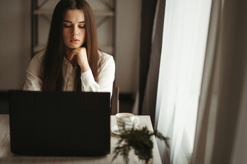 Young concentrated woman working on laptop