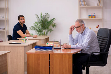 Old male teacher physicist and young male student in the classro