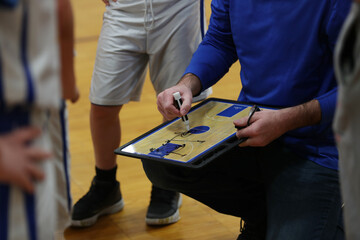 A basket ball coach diagrams a play