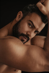 Portrait of Latin handsome shirtless man on black background