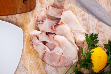 Tiger shark fillet on cutting board with lemon and parsley. Healthy food