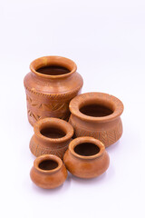 Selective focus image of earthen pots with design and patterns kept together with white background