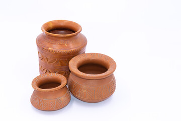 Selective focus image of earthen pots with design and patterns kept together with white background