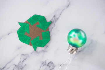 ecology and green ideas for the environment, green light bulb next to recycle logo made of cardboard