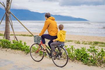Fototapeta premium Father with his son having a weekend excursion on bike on a summer day in beautiful landscape