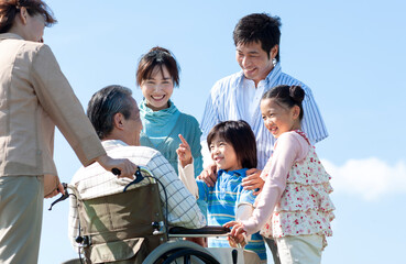 車椅子に座るシニア男性と笑顔の家族