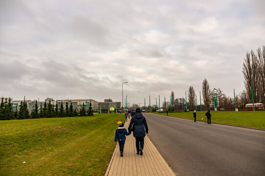 Woman and child walking on a sidewalk leading to the MPK Katarzynki event.